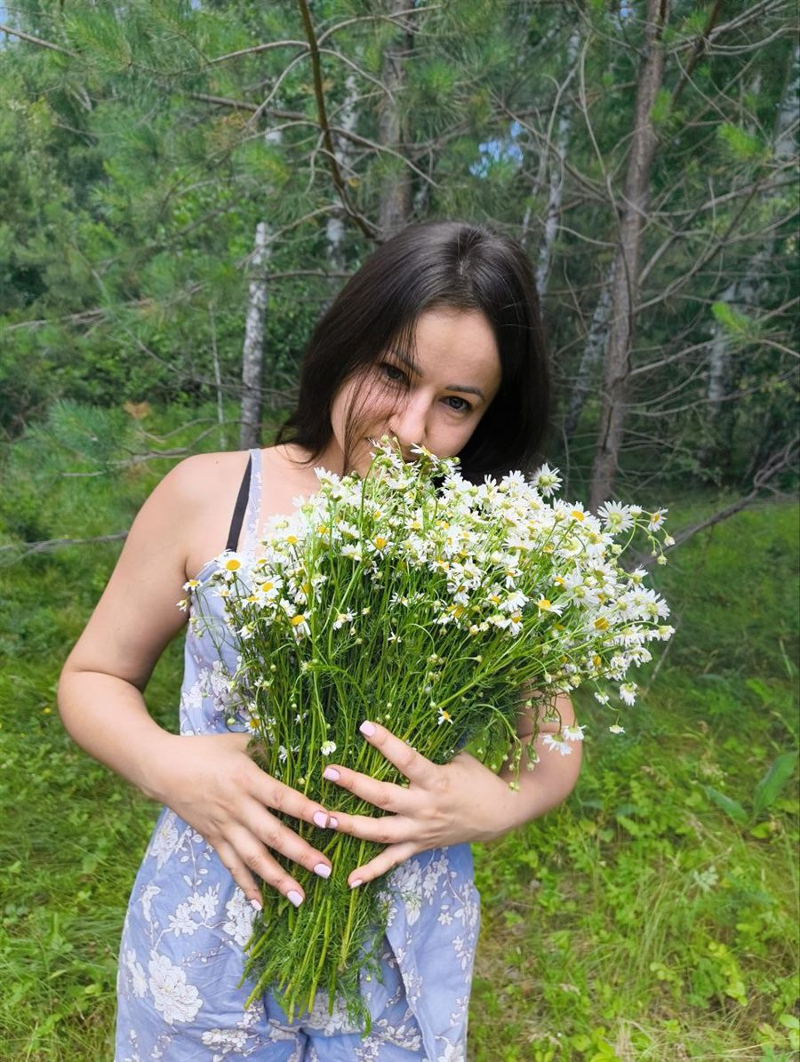 Марина Ахнина — энергоцелитель, с букетом полевых цветов в алтайском лесу